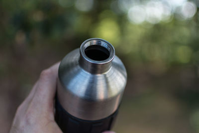 Cropped image of person holding drinking bottle