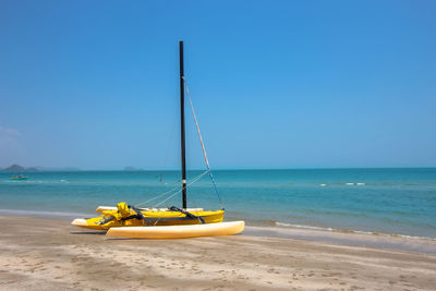 Sailboat on beach against clear blue sky