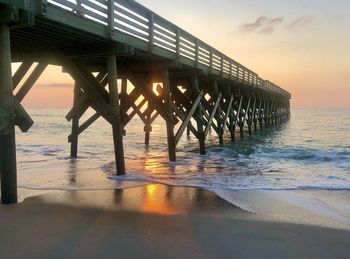 Pier over sea against sky during sunset