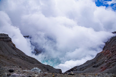 Smoke emitting from volcanic mountain against sky