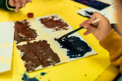 Cropped hand of woman painting