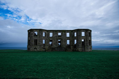 Old building on field against sky