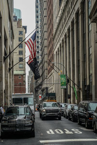 Traffic on road amidst buildings in city