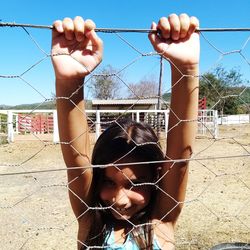 Portrait of girl holding metal fence