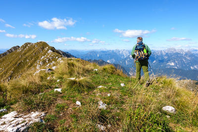 Person with umbrella on mountain against sky