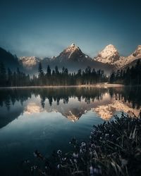 Scenic view of lake by trees against sky