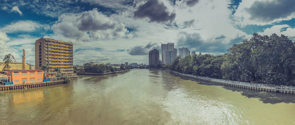 Panoramic view of river and buildings against sky