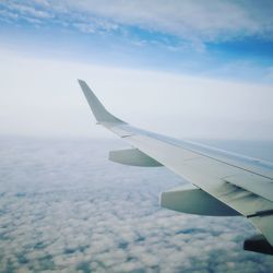 Airplane flying over clouds in sky