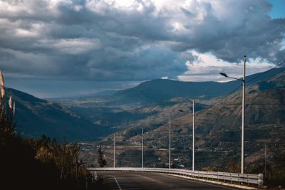 Road leading towards mountains against sky