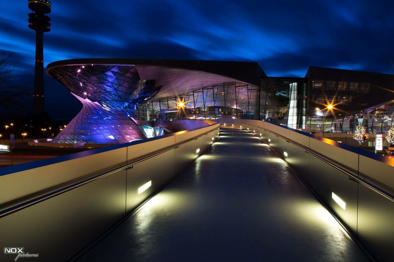 illuminated, architecture, night, built structure, transportation, street light, city, lighting equipment, building exterior, the way forward, sky, reflection, road, street, bridge - man made structure, mode of transport, city life, diminishing perspective, car, connection