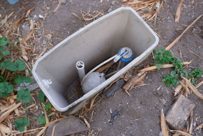 High angle view of abandoned container on field