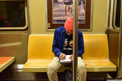 Rear view of man sitting in train