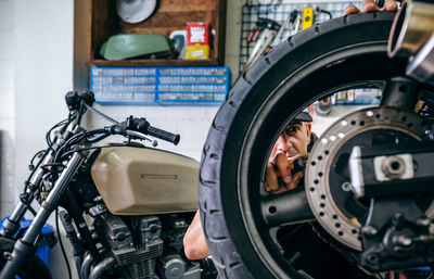 Man repairing motorcycle in garage