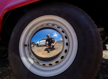 Reflection of man in side-view mirror