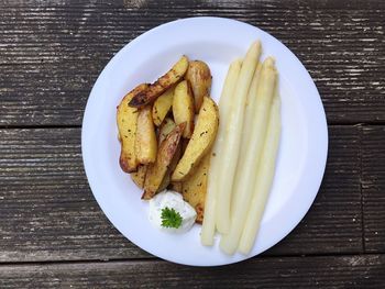 Directly above shot of fried potatoes and white asparagus on plate