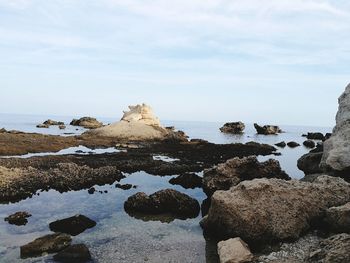 Rocks on beach against sky