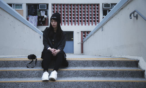 Full length of woman sitting on staircase