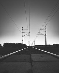 Electricity pylons against clear sky