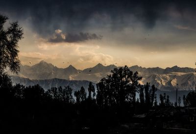 Scenic view of silhouette mountains against sky at sunset