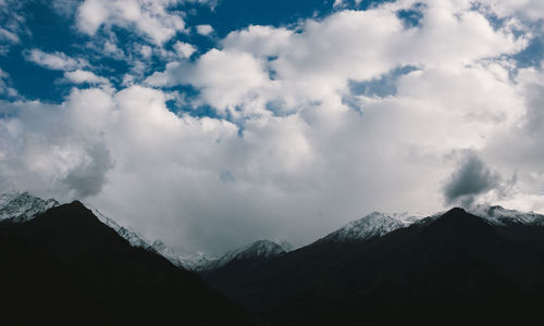 Scenic view of mountains against cloudy sky