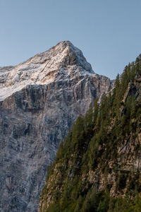 Low angle view of rocky mountains against clear sky