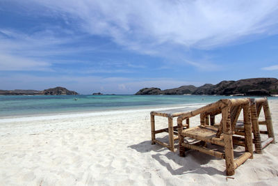 Chairs on beach against sky