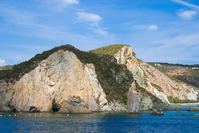 Rock formations by sea against sky