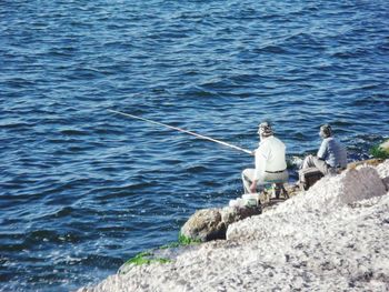 High angle view of men fishing at shore