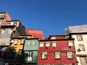 Low angle view of houses against clear blue sky