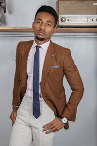 Portrait of young man standing against wall