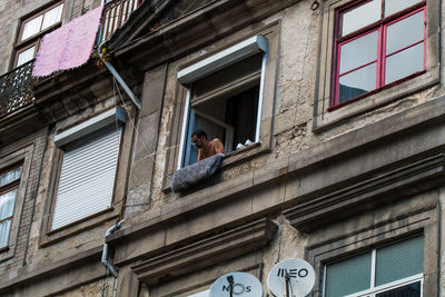 Low angle view of man standing by building