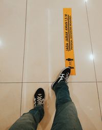 Low section of man standing on tiled floor