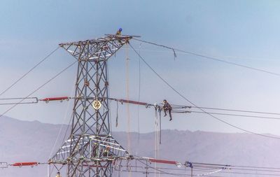 Low angle view of electricity pylon against the sky