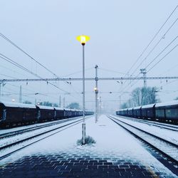 Illuminated railroad station against sky during winter
