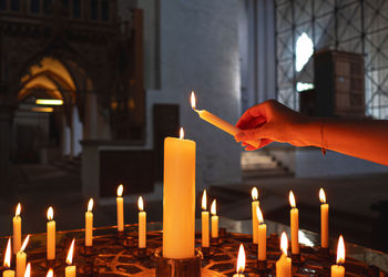 Close-up of hand lighting candles