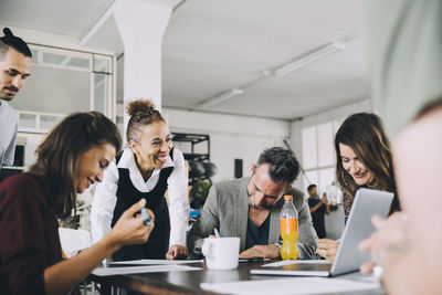 Smiling creative business people working at table in office