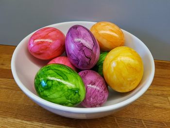 High angle view of multi colored eggs in plate on table