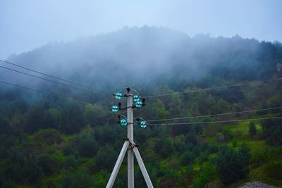 Low angle view of telephone pole against sky