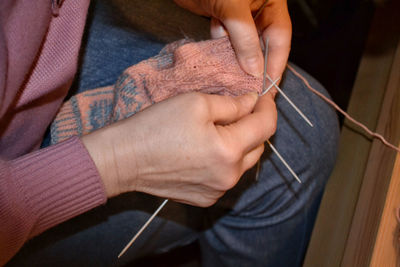 Midsection of woman knitting wool