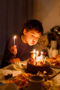 Young man with candles on birthday cake