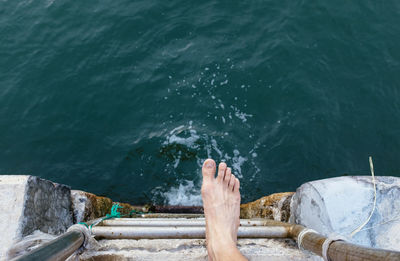 High angle view of human foot next to water