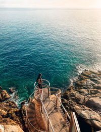 High angle view of rocks by sea against sky