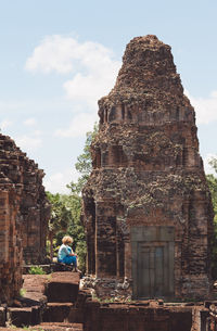 Side view of woman sitting at temple old ruin