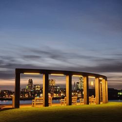 Illuminated building against sky at sunset