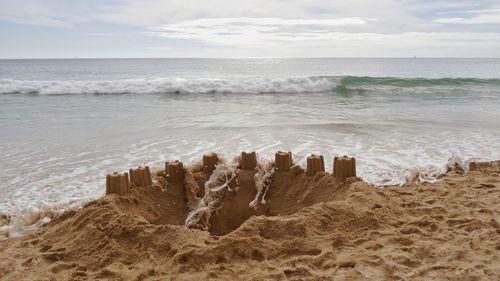 Sand castle catched by waves