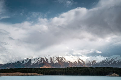 A scenic landscape of new zealand southern alps and lake pukaki with blue sky and clouds.