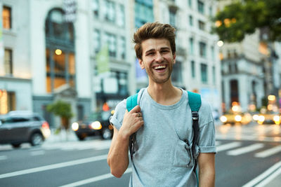 Portrait of young man standing on city street