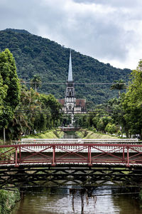 Bridge over river amidst buildings against sky