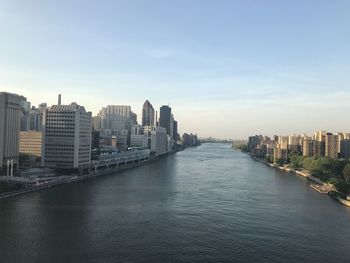 River amidst buildings in roosevelt  island against sky.