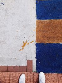 Low section of person standing on tiled floor